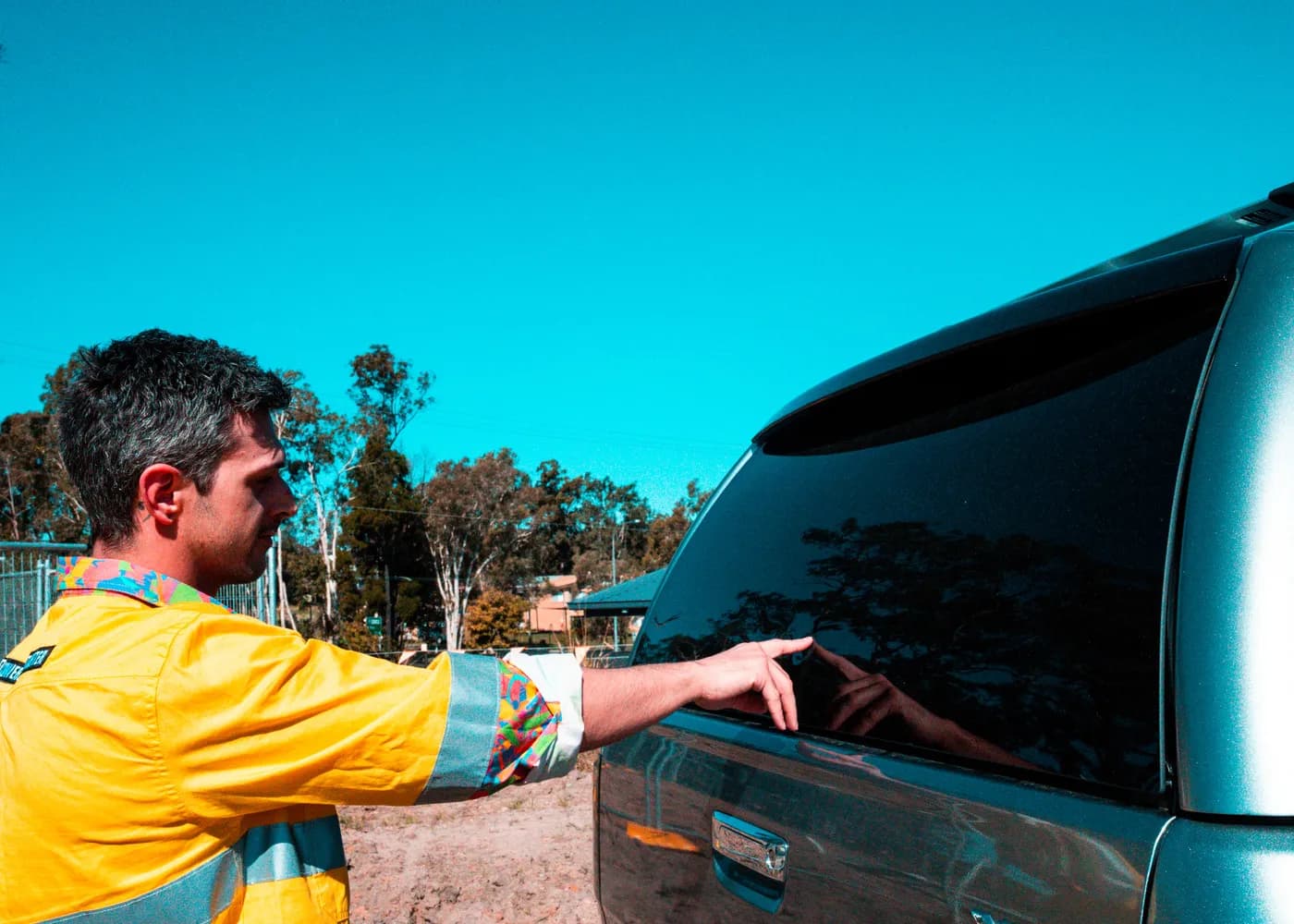 Man pressing the handle-free rear window of an EGR GEN3 Canopy to open it with push-button access
