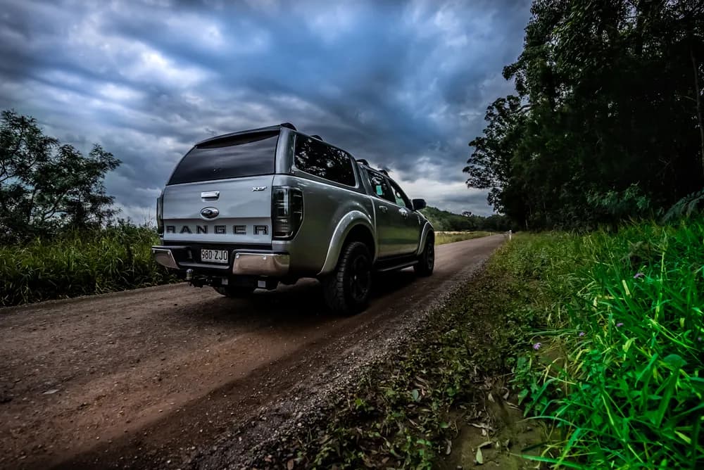 Rear view of a Ford Ranger with an EGR canopy parked in a bush setting