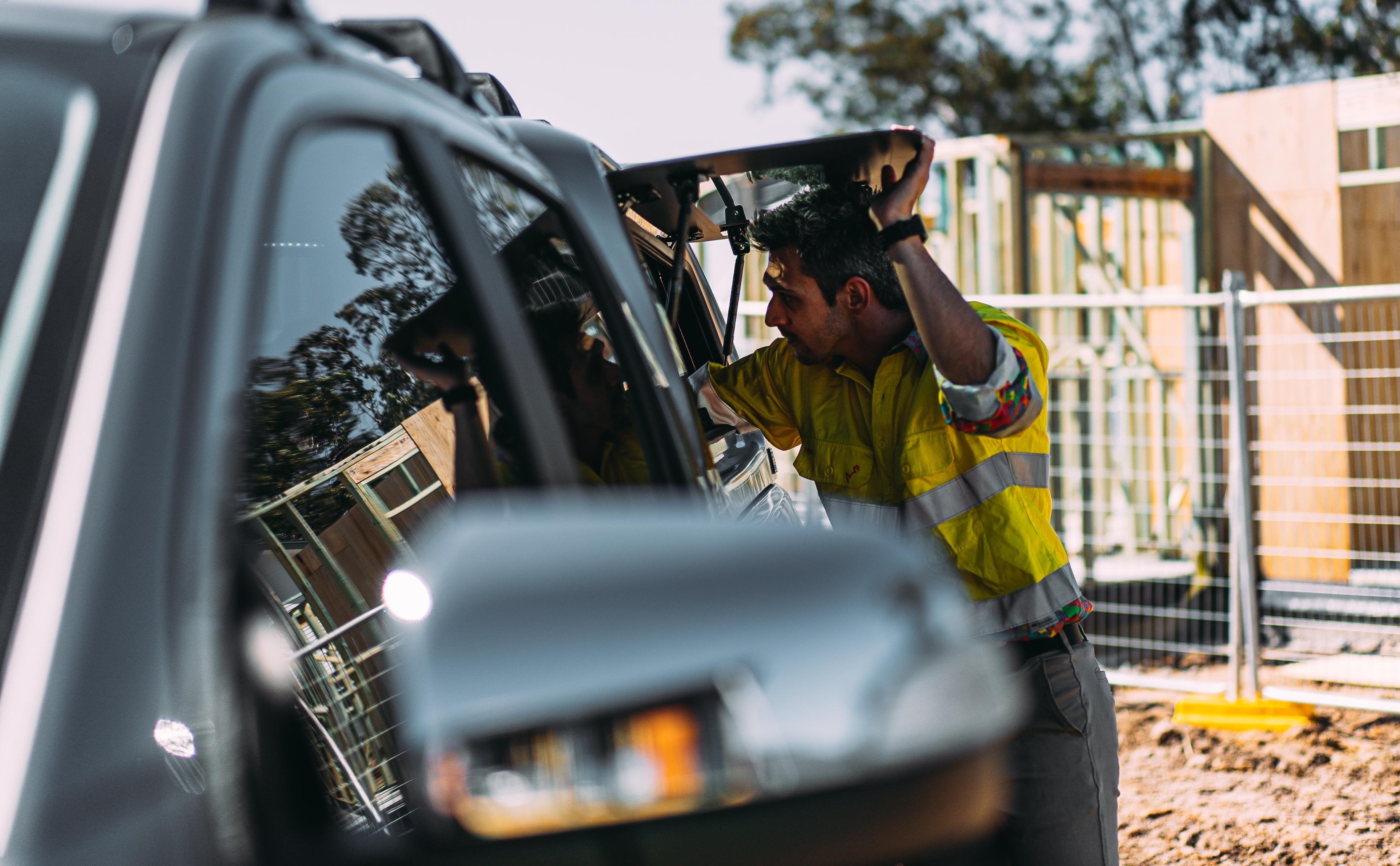 a man reaching inside an open EGR canopy on his vehicle