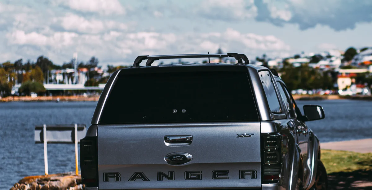 Utes with EGR canopy roof rack kits driving on a dirt road