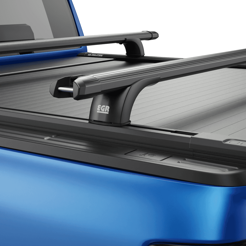 Detail view of black powder-coated RollTrac crossbar showing steel construction and mounting brackets