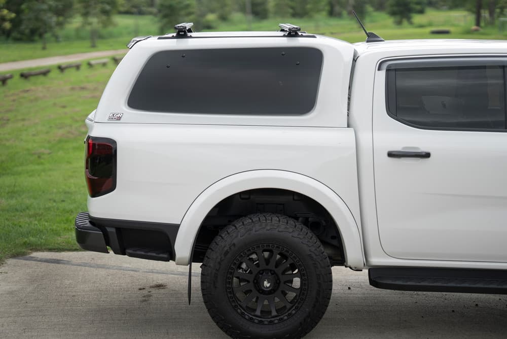 Rear three-quarter view of vehicle with EGR Gen3 canopy and Yakima TrimHD crossbars installed for added load capacity