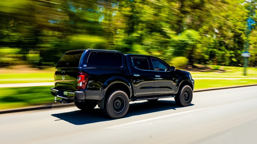 Rear three-quarter view of black Nissan Navara MY21 equipped with EGR GEN3 Canopy, showing push-button rear door and smooth canopy profile
