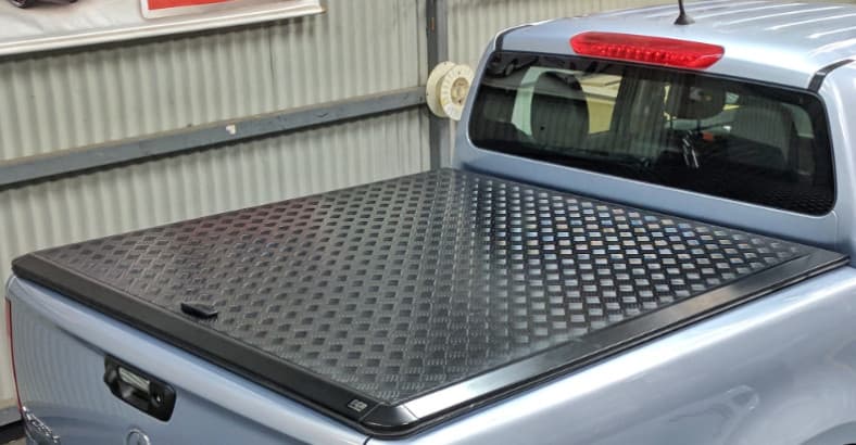 Close-up of the EGR Load Shield aluminium checker-plate cover and mounting rails on a Mazda BT-50 2020 model