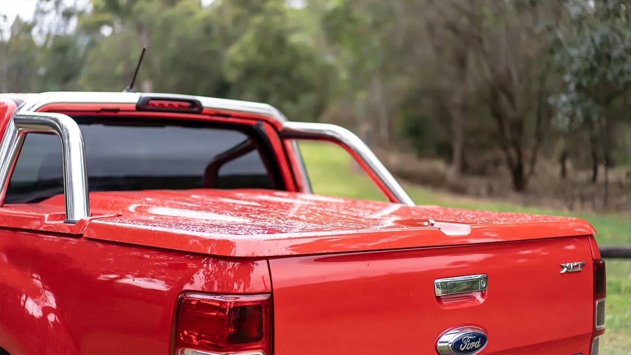 Side view of a ute with an EGR hard lid and accessories in a rural setting